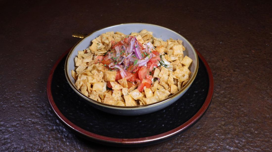 Crispy chaat topped with tomato and onion