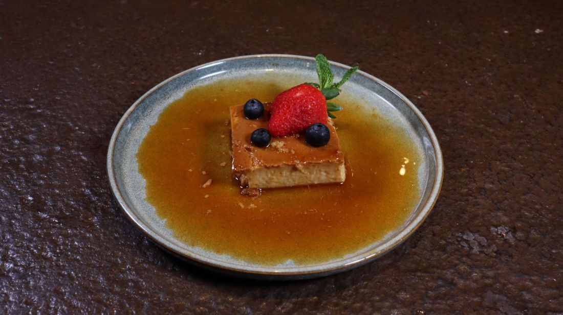 Caramel flan topped with strawberry and blueberries